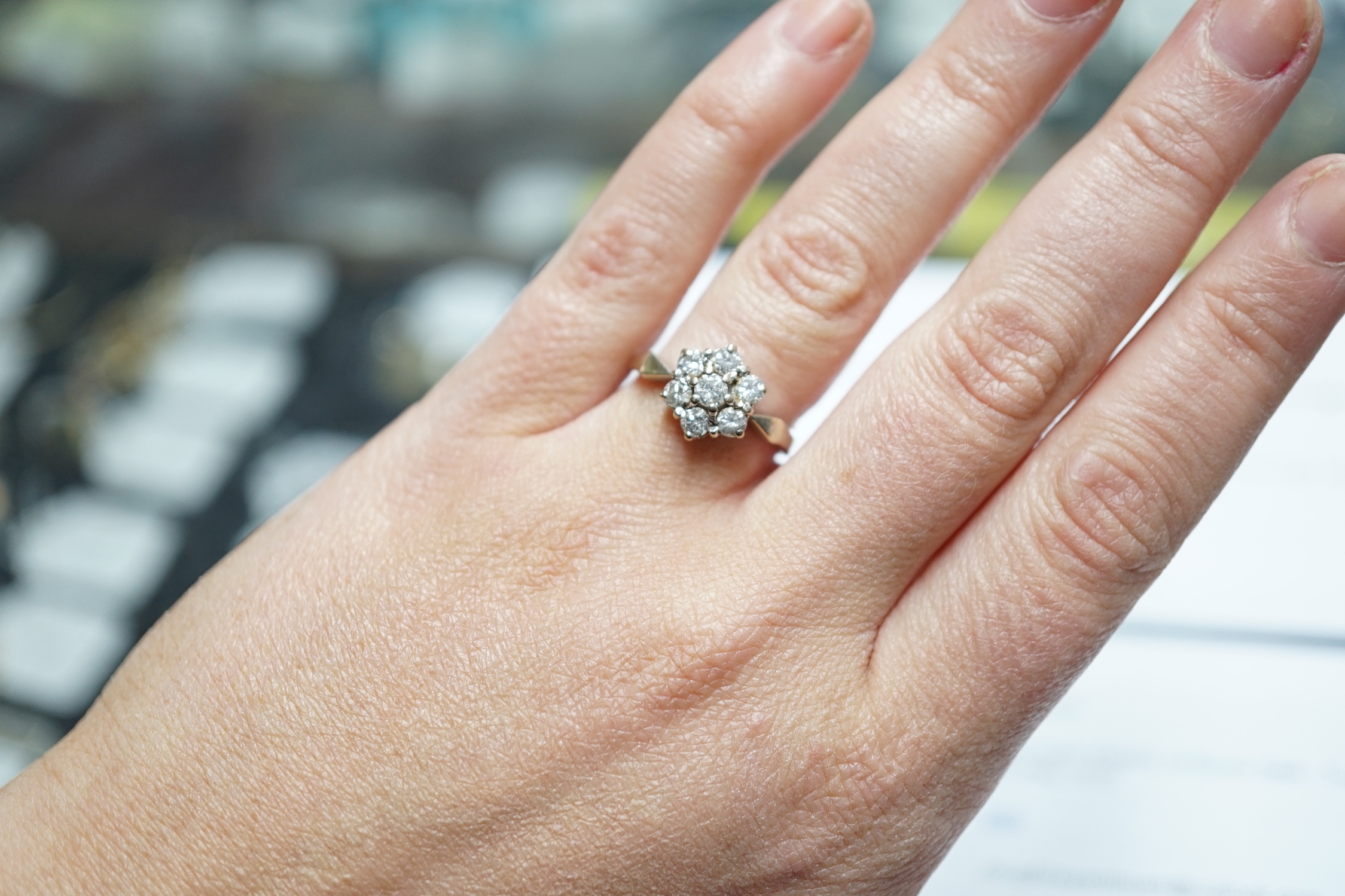 A modern 18ct white gold and seven stone diamond set hexagonal cluster ring, size O, gross weight 3.9 grams.